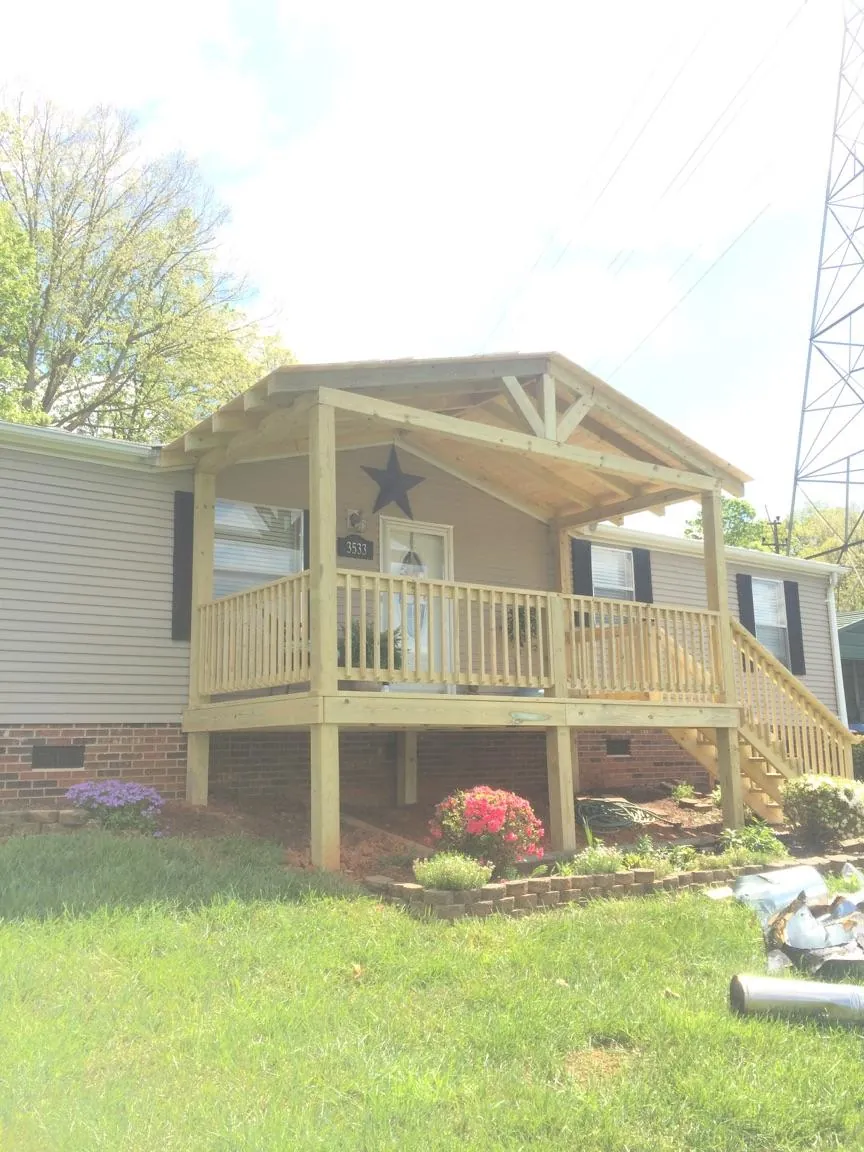 New gabled porch roof and deck railing added to a ranch home in Howell